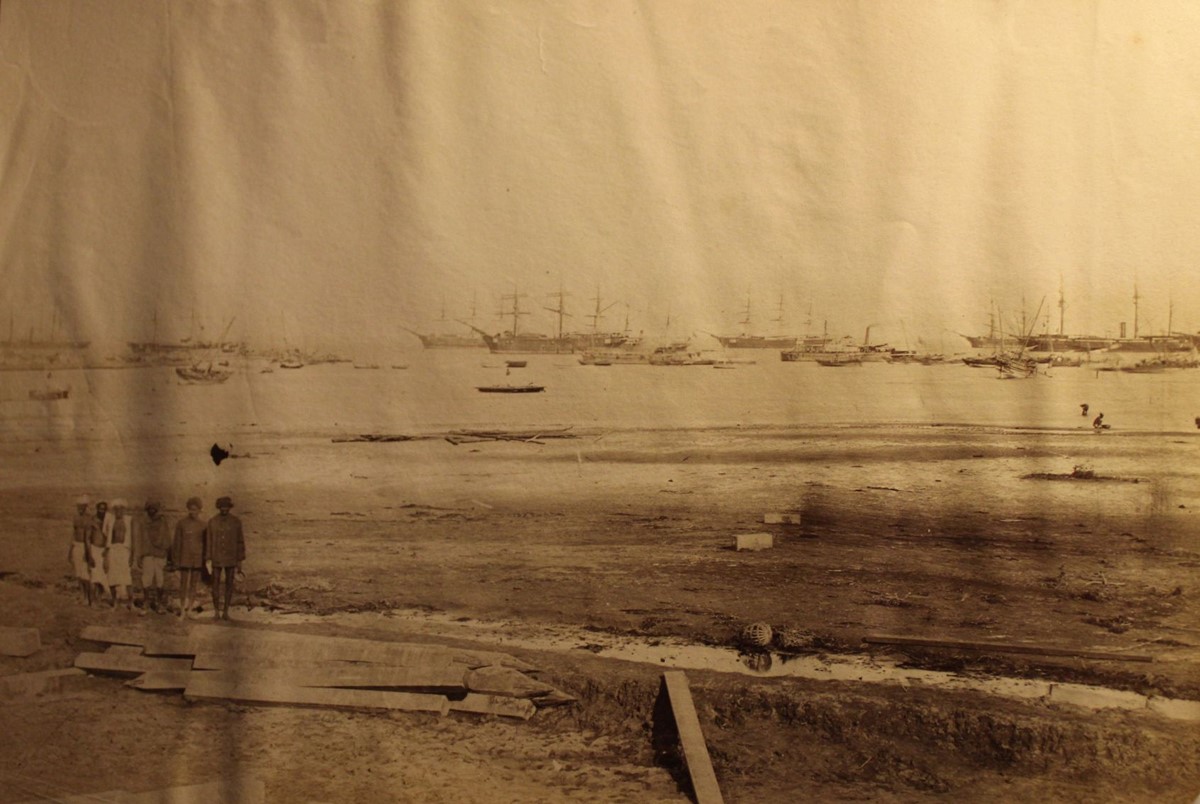 photo of various sailing ships moored offshore.